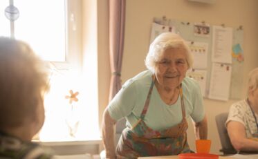 Freundliche Bewohnerin beim Töpfern in der Tagespflege