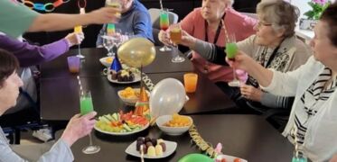 Ältere Menschen sitzen zusammen an einem geschmückten Tisch